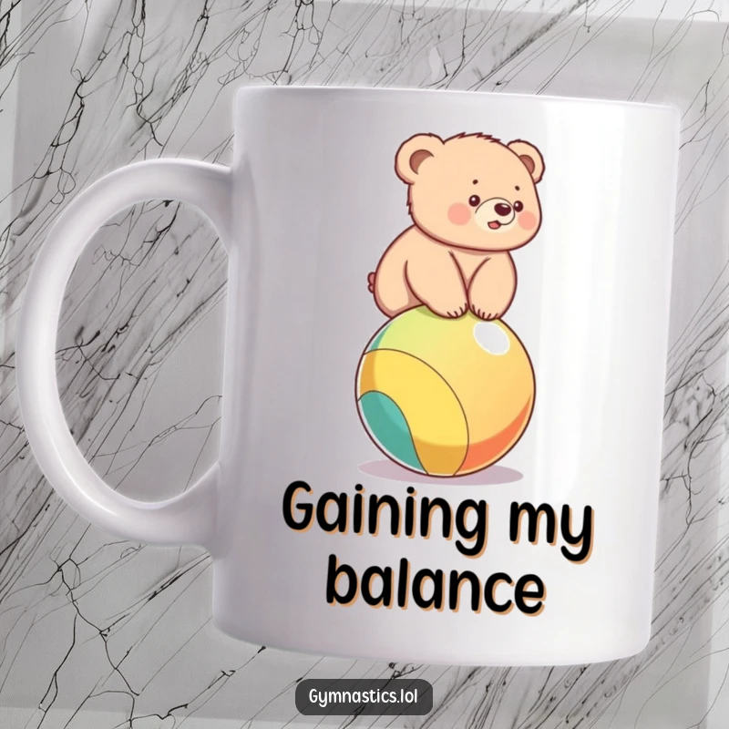Funny mug featuring a cute bear cub hilariously struggling to balance on a big, colorful ball, looking determined.