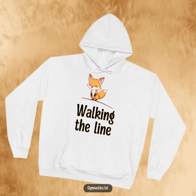Funny fox hoodie depicting a determined fox precariously balancing on a balance beam, offering warmth and comedic encouragement.