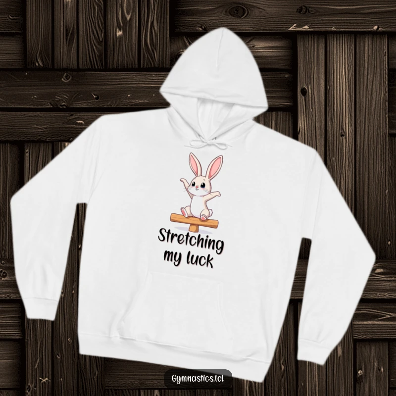 Funny bunny hoodie with a curious bunny stretching on a balance beam, looking up, embodying grace and determination, ideal for active lifestyles.